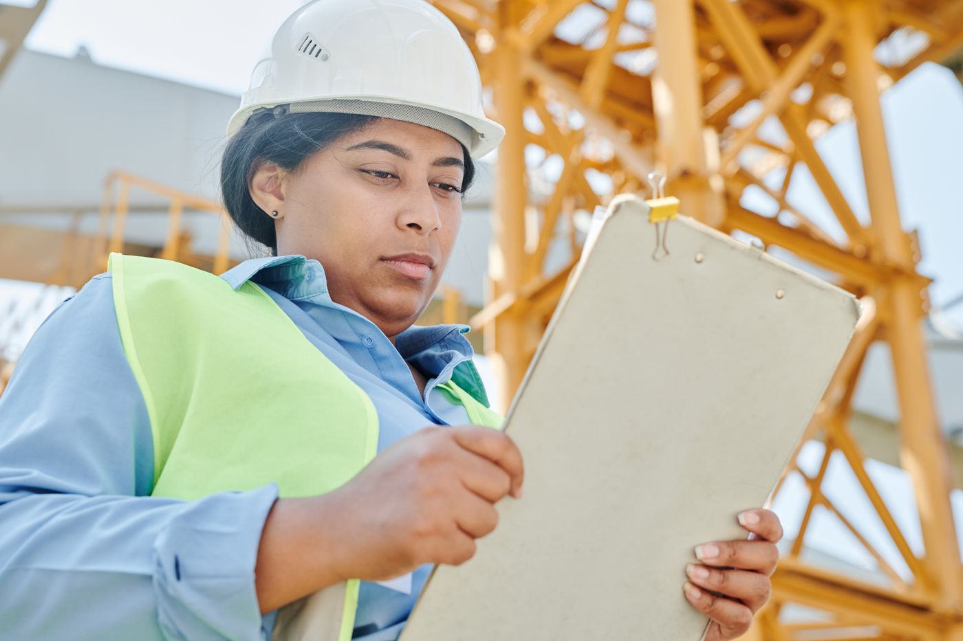 An officer in a safety vest filling in a form on a clipboard